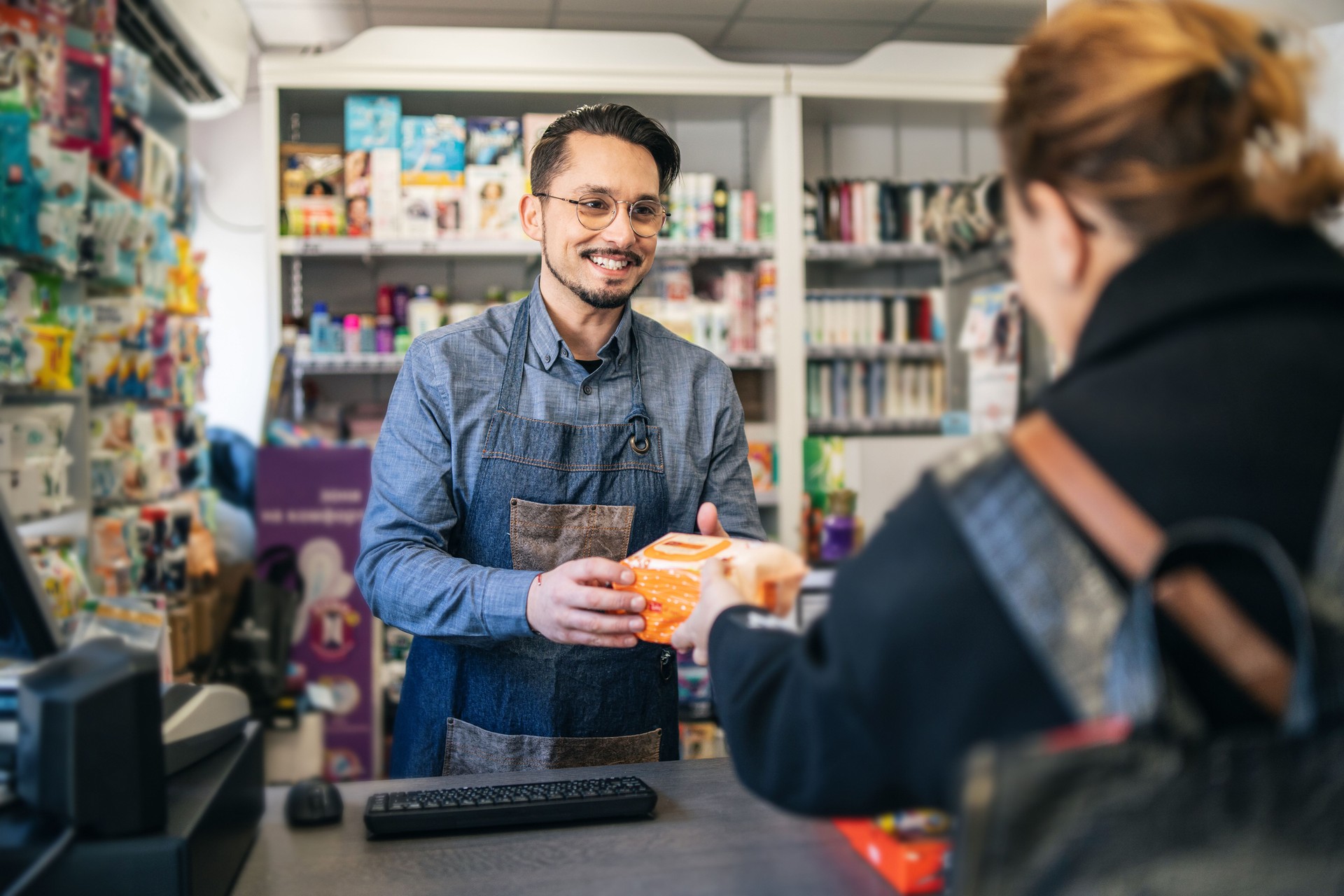 Erfolgreicher Besitzer im Supermarkt bei der Registrierung von Produkten